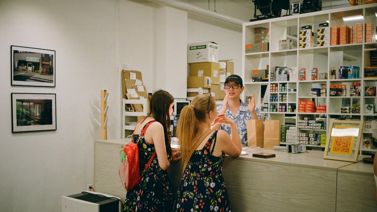 Two customers talking with a shop assistant at a counter